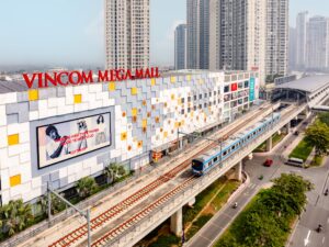 Mặt ngoài Vincom Mega Mall Thảo Điền với tàu metro trên đường ray phía trước